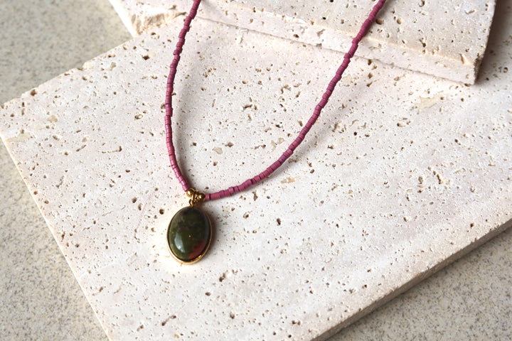Necklace with a green pendant on purple natural stone