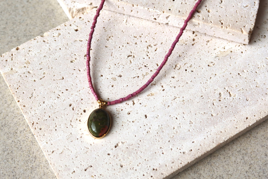 Necklace with a green pendant on purple natural stone
