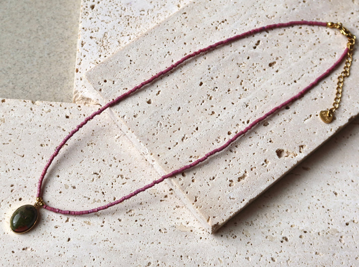 Necklace with a green pendant on purple natural stone